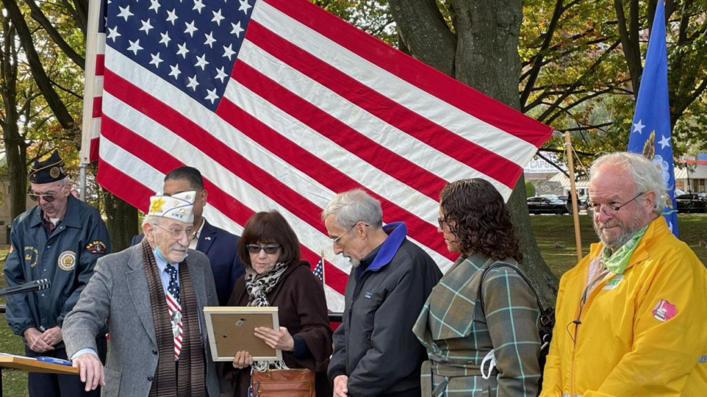 group of people standing in front of American flag at a podium